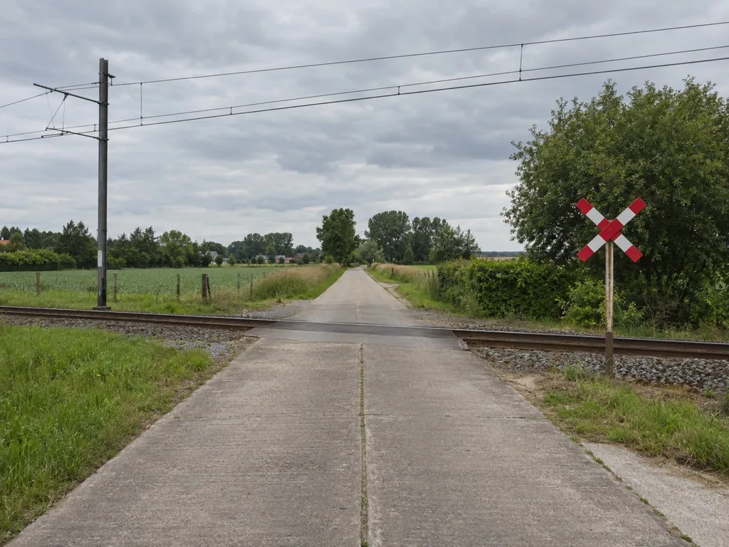 Een overweg zonder slagbomen en zonder lichten op een landweg.