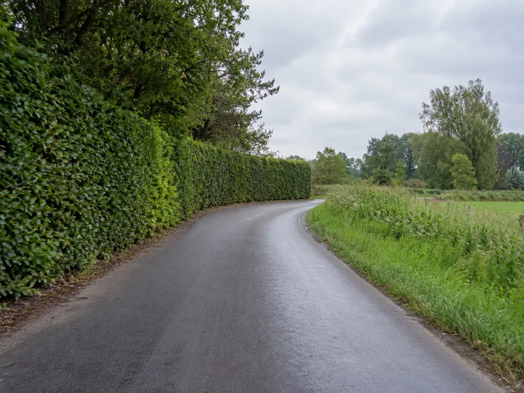 Bocht in een landelijke weg met beperkt zicht en een vrije plaats langs de rand.